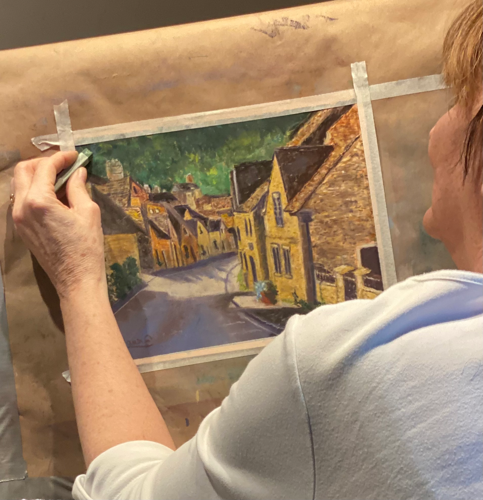 DawnE at work in her studio, painting a pastel landscape